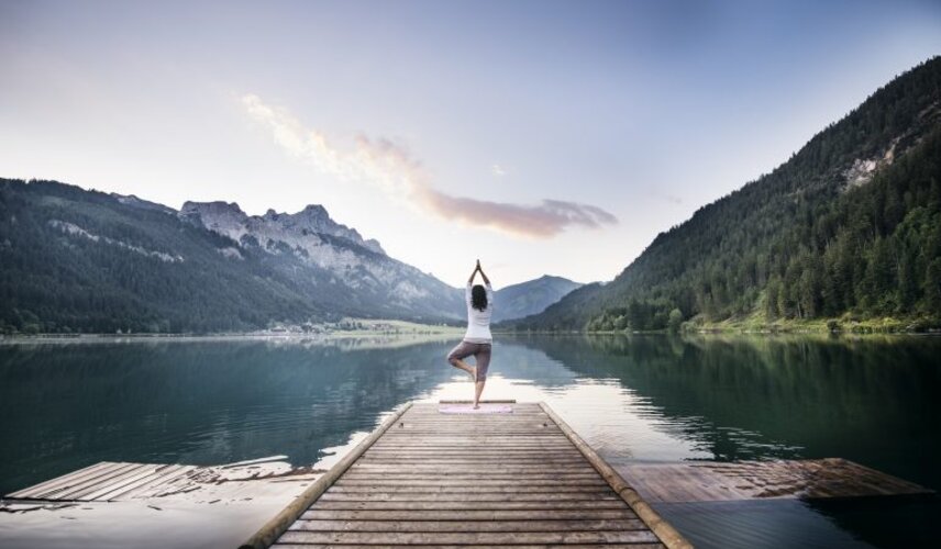 Eine Frau macht Yoga am See beim Hotel Theresa im Zillertal