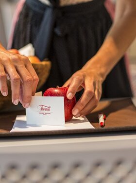 Woman prepares an apple and a business card for seminars at the Seminarhotel Theresa in Zillertal