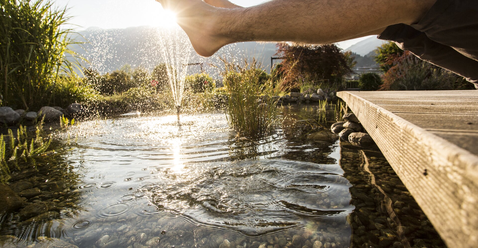Füße baumeln im Teich des Gartens vom Hotel Theresa im Zillertal