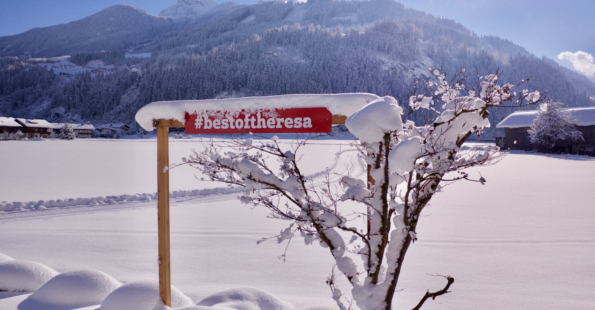 Das Logo bestoftheresa steht im Schnee vor dem Hotel Theresa im Zillertal