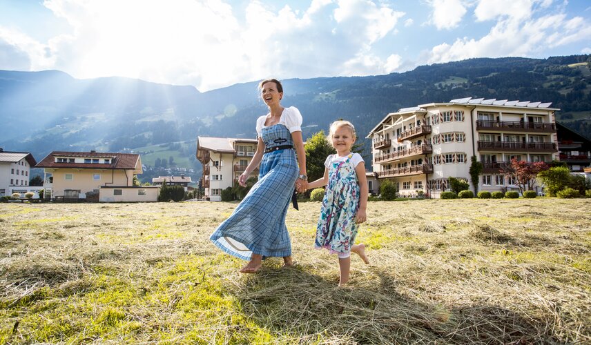Mutter und Kind genießen den Frühling im Heu des Hotel Theresa
