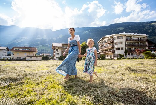 Mutter und Kind genießen den Frühling im Heu des Hotel Theresa