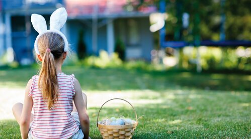 A child with bunny ears sits with an Easter basket at the Hotel Theresa