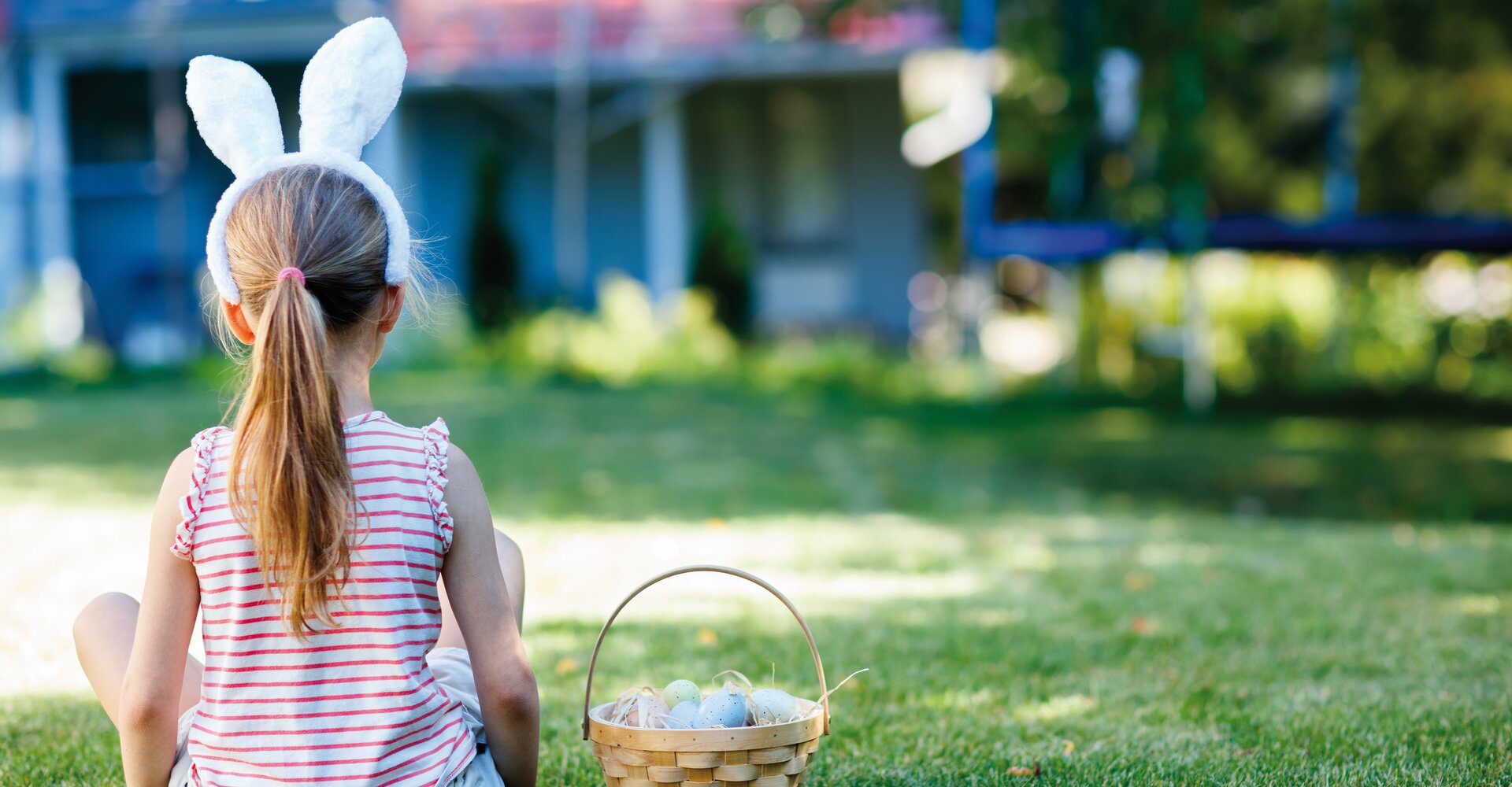 A child with bunny ears sits with an Easter basket at the Hotel Theresa