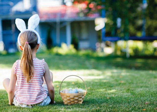 A child with bunny ears sits with an Easter basket at the Hotel Theresa