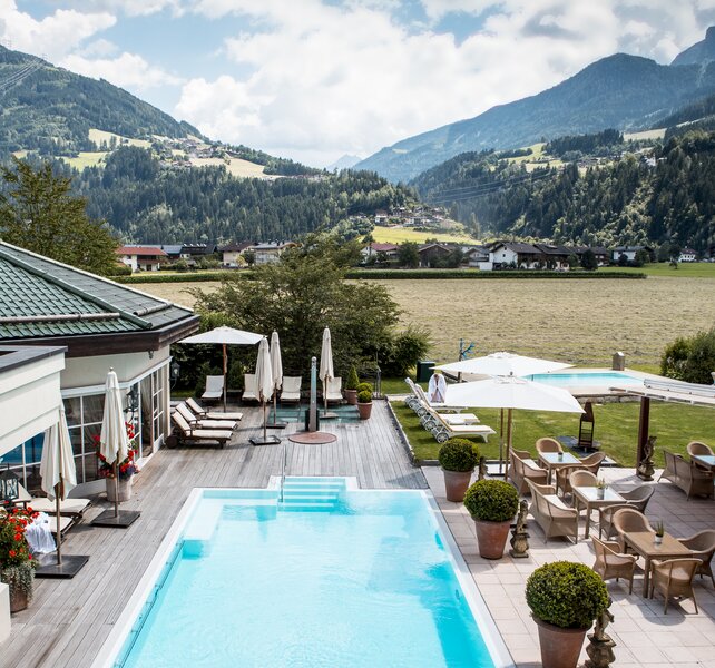 The view from the pool at Hotel Theresa Zillertal shows a woman on a lilo