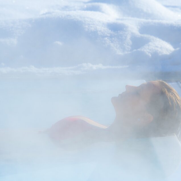 A woman relaxes in the saltwater pool at the Hotel Theresa Zillertal in winter