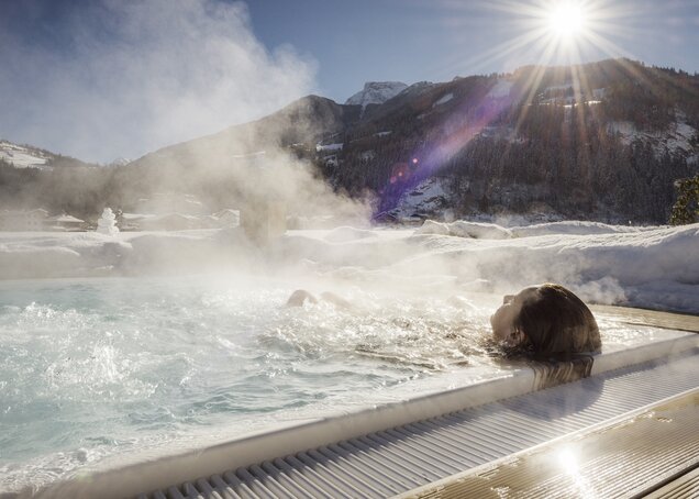 A person relaxes in the warm brine pool in winter in the Hotel Theresa