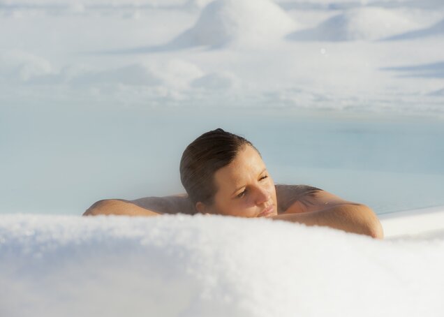 A woman enjoys winter in the brine pool of Hotel Theresa in Zillertal