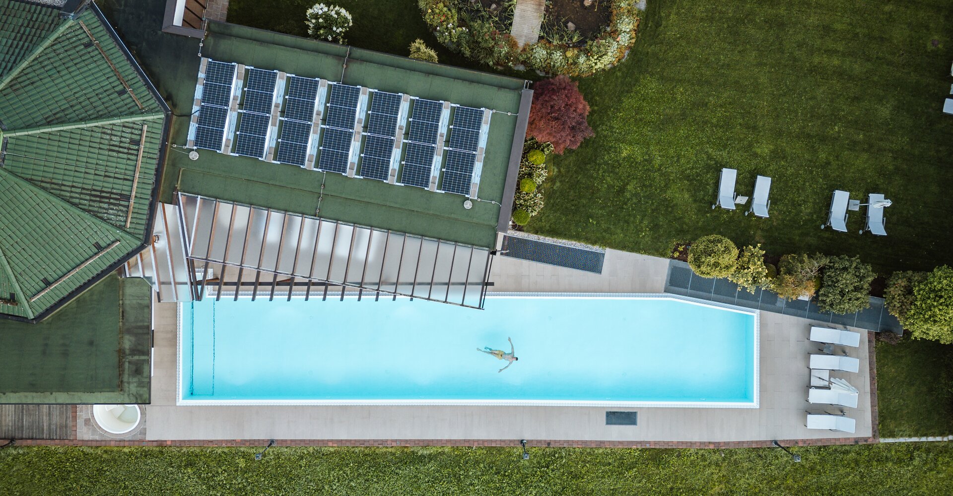 Drohnenaufnahme zeigt eine Person beim Schwimmen im Außenbecken des Wellnesshotel Theresa im Zillertal | © Carmen Huter