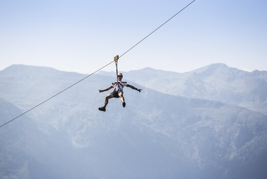Ein Mann saust mit dem Almflieger in Gerlosstein/Hainzenberg an einem Seil entlang