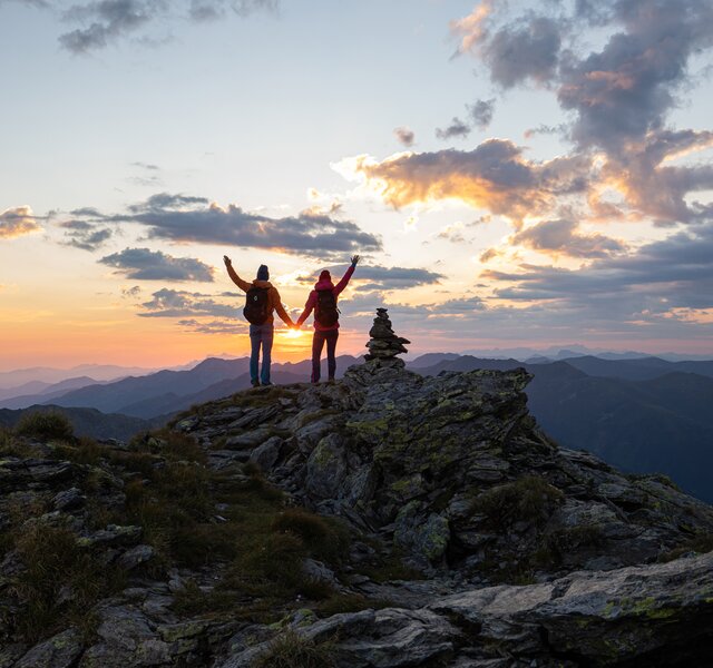 Zwei Personen stehen bei Sonnenaufgang auf dem Kreuzjoch in der Zillertal Arena
