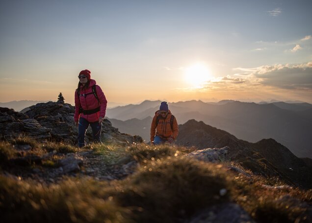 Ein Paar wandert bei Sonnenaufgang am Kreuzjoch