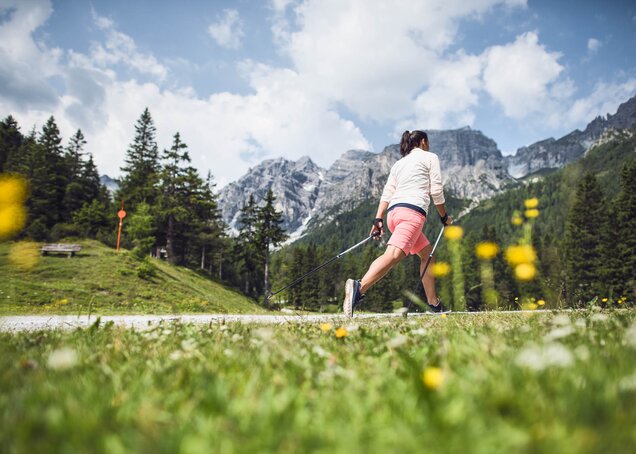 Eine Frau walkt mit Stöcken auf einem Weg im Zillertal beim Hotel Theresa