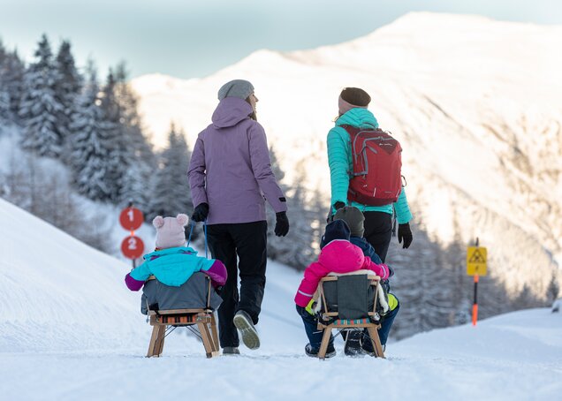 A family goes on a winter hike on the Almpromenade at Gerlosstein