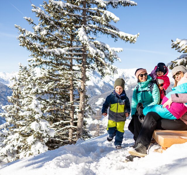A family goes on a winter hike on the Almpromenade at Gerlosstein