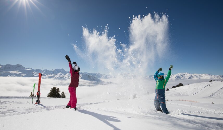 Im strahlenden Sonnenschein toben Kinder im Winter in der Zillertal Arena im Schnee