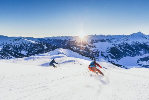 Zwei Skifahrer fahren bei Königsleiten in der Zillertal Arena Ski
