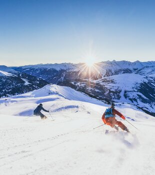 Zwei Skifahrer fahren bei Königsleiten in der Zillertal Arena Ski